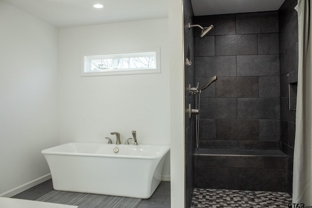 full bathroom with baseboards, tiled shower, and a soaking tub