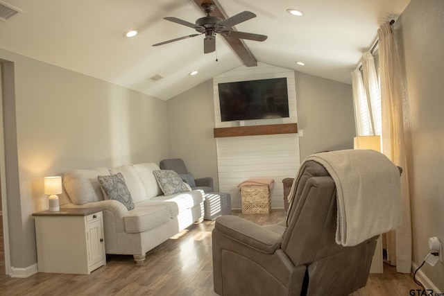 living area featuring visible vents, light wood-type flooring, lofted ceiling with beams, and ceiling fan