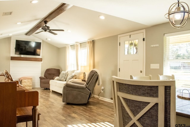 living area with a wealth of natural light, visible vents, light wood-style floors, and lofted ceiling with beams