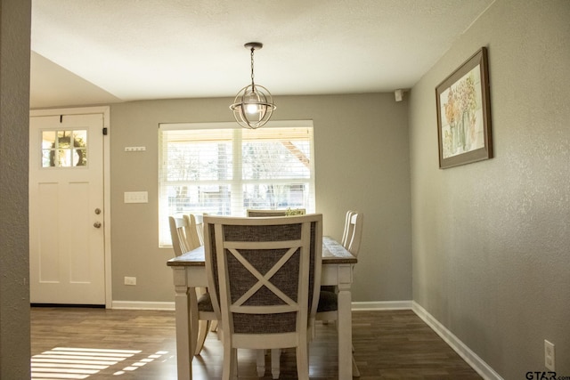 dining space featuring baseboards and wood finished floors