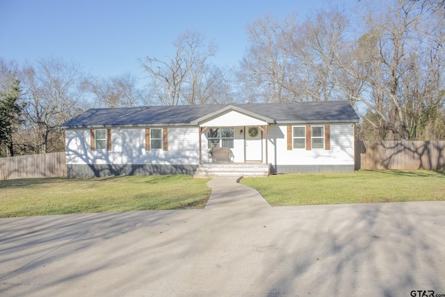 view of front of home featuring a front lawn and fence