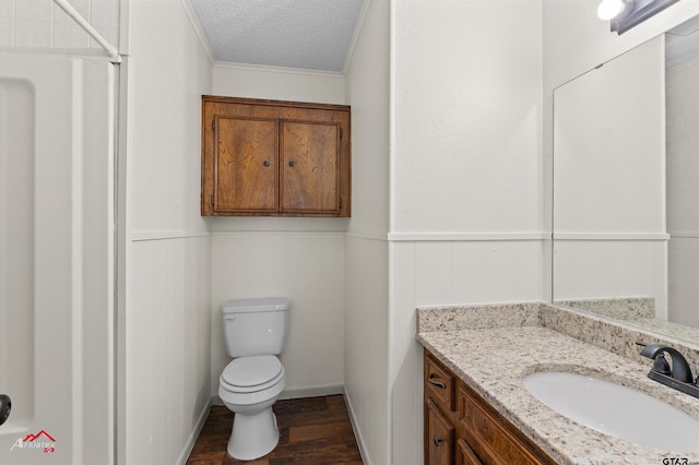 197 Sherman St, Rusk, TX 75785 - bathroom with a textured ceiling, vanity, toilet, wood finished floors, and wainscoting