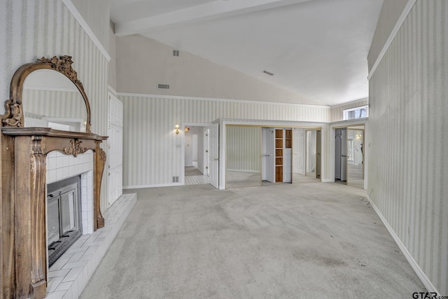 unfurnished living room with visible vents, a tiled fireplace, beamed ceiling, carpet floors, and high vaulted ceiling