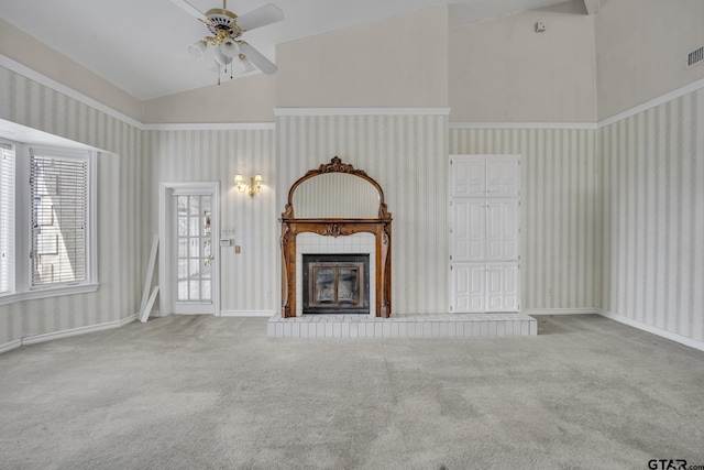 unfurnished living room featuring high vaulted ceiling, a glass covered fireplace, carpet flooring, and wallpapered walls