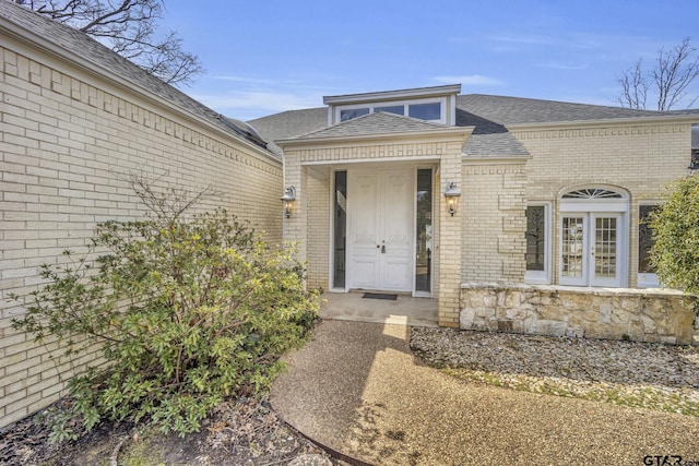 property entrance with brick siding and roof with shingles