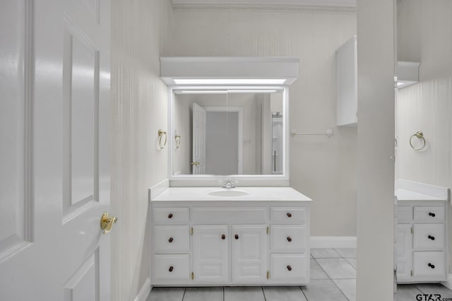 bathroom featuring tile patterned flooring, baseboards, and vanity