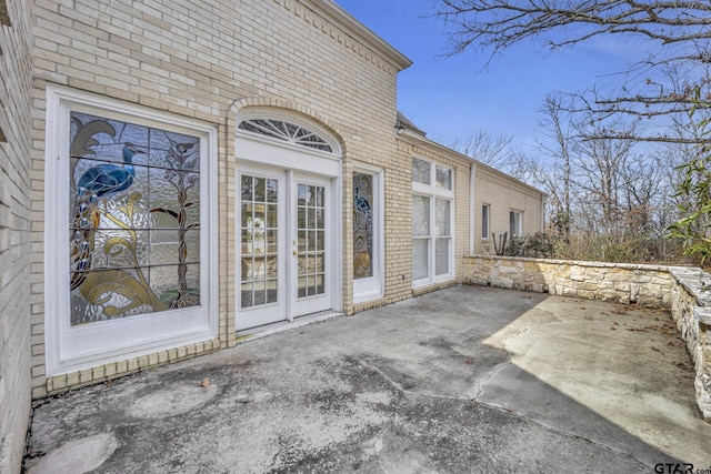 doorway to property with a patio and brick siding