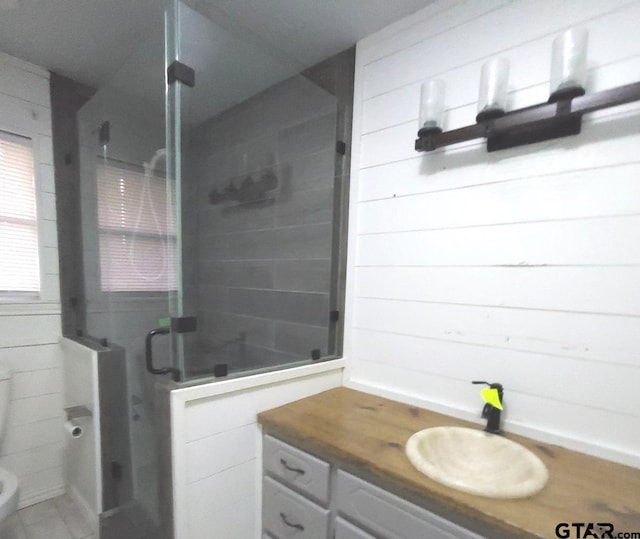 bathroom with a shower with door, vanity, and toilet