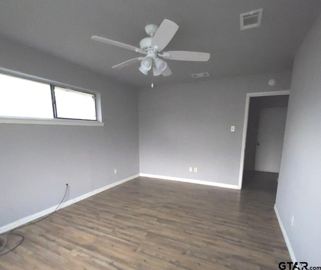 empty room with dark hardwood / wood-style flooring and ceiling fan