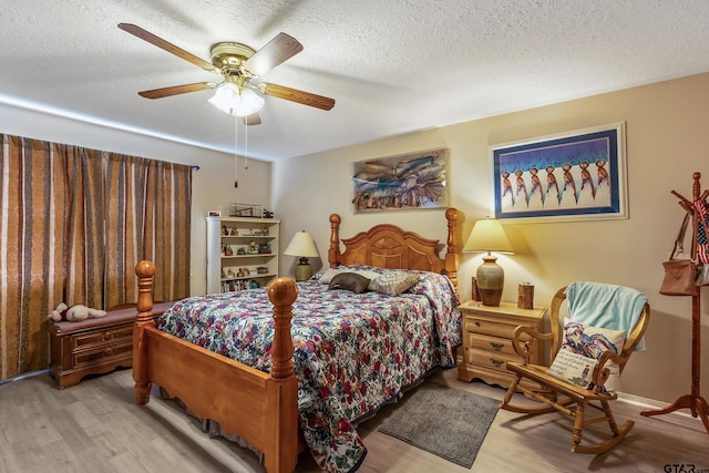 bedroom with a textured ceiling, a ceiling fan, and wood finished floors