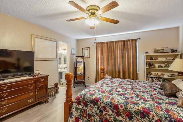 bedroom featuring a ceiling fan, connected bathroom, light wood-style floors, and a textured ceiling