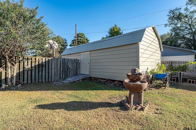 view of yard with a fenced backyard, a storage unit, and an outdoor structure