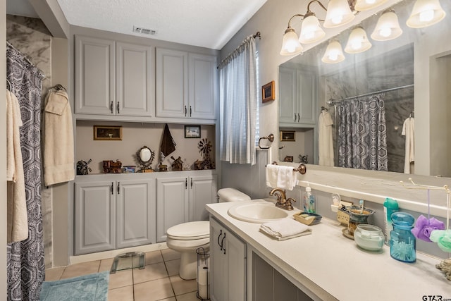 bathroom featuring vanity, visible vents, a textured ceiling, tile patterned floors, and toilet