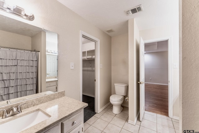 1881 Woodbridge Dr, Sulphur Springs, TX 75482 - full bath with tile patterned floors, toilet, vanity, a textured wall, and baseboards