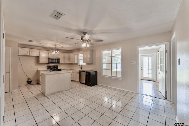 1881 Woodbridge Dr, Sulphur Springs, TX 75482 - kitchen featuring appliances with stainless steel finishes, light tile patterned flooring, light countertops, ceiling fan, and a kitchen island