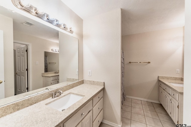 1881 Woodbridge Dr, Sulphur Springs, TX 75482 - bathroom with two vanities, baseboards, and tile patterned flooring