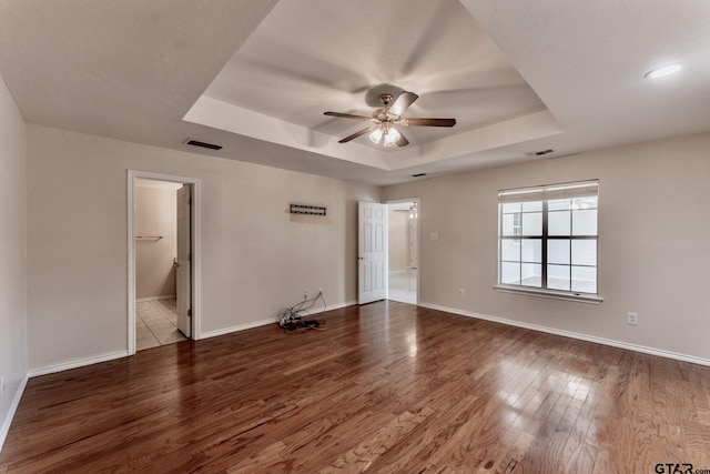 1881 Woodbridge Dr, Sulphur Springs, TX 75482 - spare room with a tray ceiling, wood finished floors, ceiling fan, and baseboards