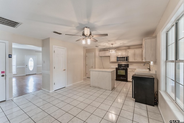 1881 Woodbridge Dr, Sulphur Springs, TX 75482 - kitchen featuring electric range, stainless steel microwave, light countertops, a sink, and a center island