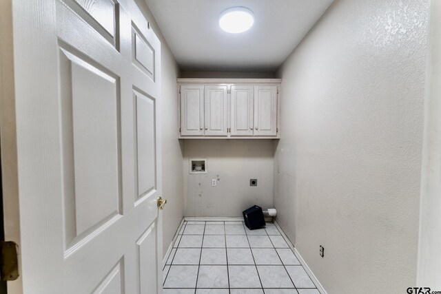 1881 Woodbridge Dr, Sulphur Springs, TX 75482 - laundry room featuring electric dryer hookup, washer hookup, light tile patterned floors, cabinet space, and baseboards