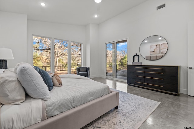 bedroom featuring access to exterior, a high ceiling, and multiple windows