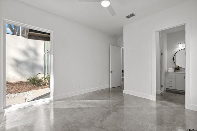 unfurnished bedroom featuring ceiling fan, concrete flooring, and connected bathroom