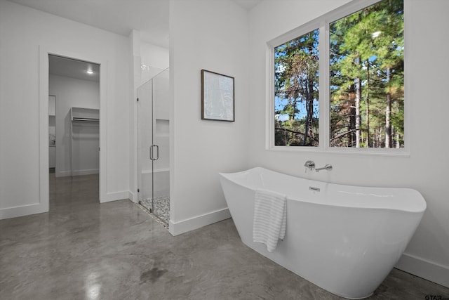 bathroom with concrete flooring and shower with separate bathtub