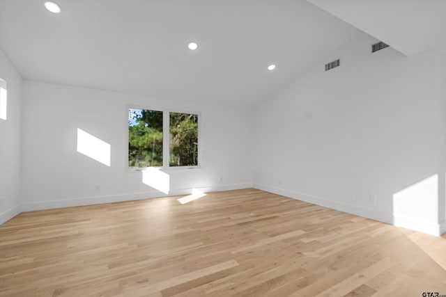 unfurnished room featuring light wood-type flooring and vaulted ceiling