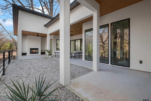 view of patio / terrace with ceiling fan and exterior fireplace