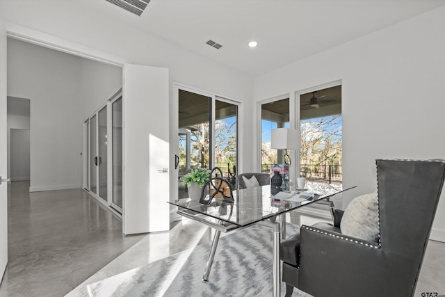 dining area with concrete flooring and ceiling fan