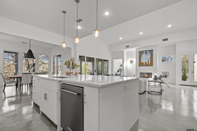 kitchen with white cabinets, pendant lighting, a center island with sink, and plenty of natural light