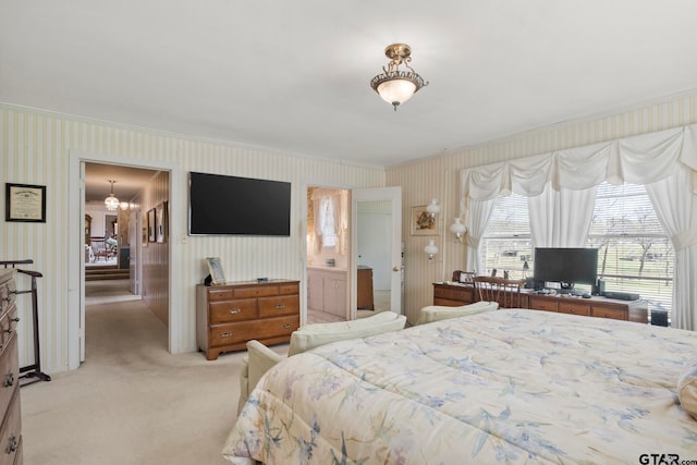 bedroom with a chandelier, ensuite bath, light carpet, and crown molding