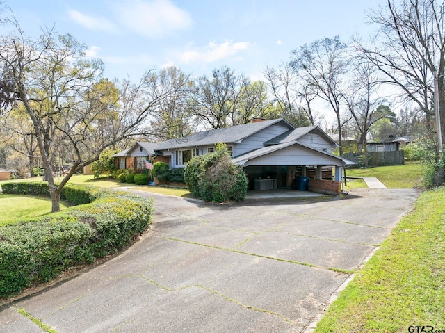 view of front of home with a front yard and a carport