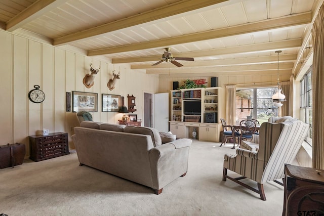 living room featuring beamed ceiling, ceiling fan, and carpet floors