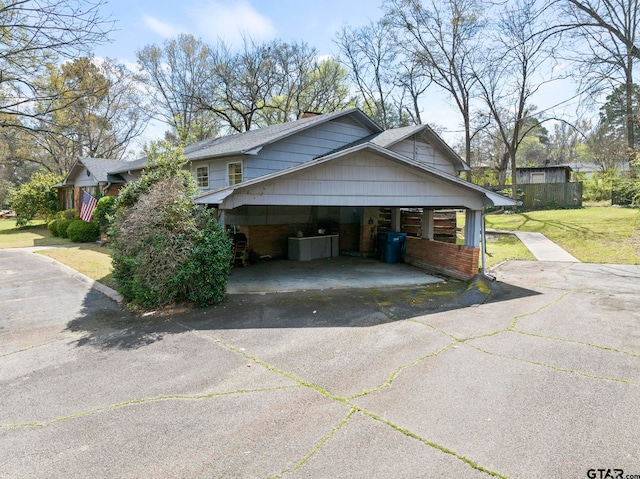 view of home's exterior with a carport and a lawn