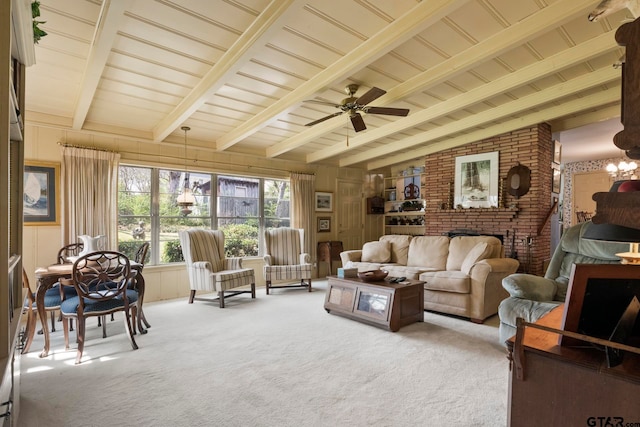 carpeted living room featuring a fireplace, wood walls, ceiling fan, and beam ceiling