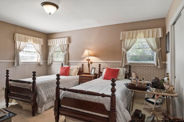 carpeted bedroom featuring a closet and multiple windows