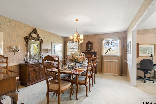 carpeted dining space with a notable chandelier