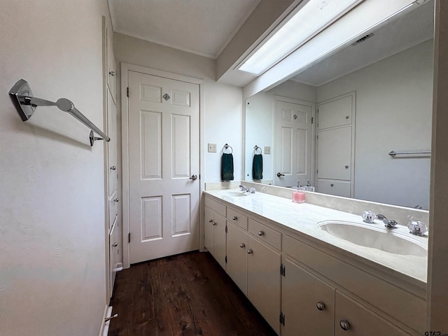 full bathroom with wood finished floors, a sink, and double vanity