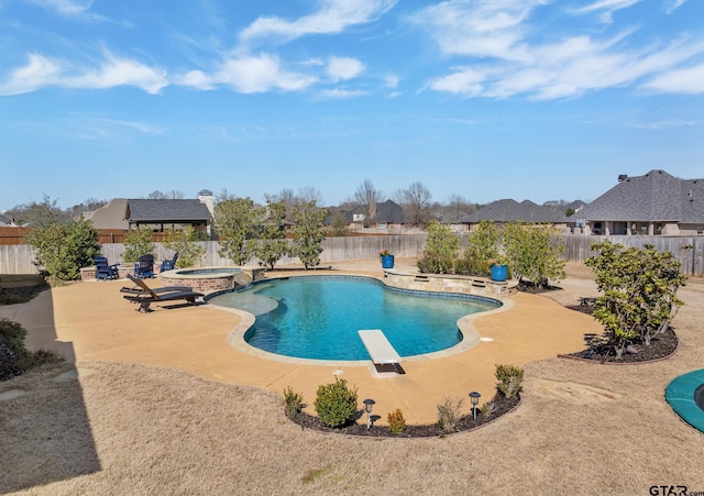 view of pool featuring a diving board, a patio area, a fenced backyard, and a pool with connected hot tub