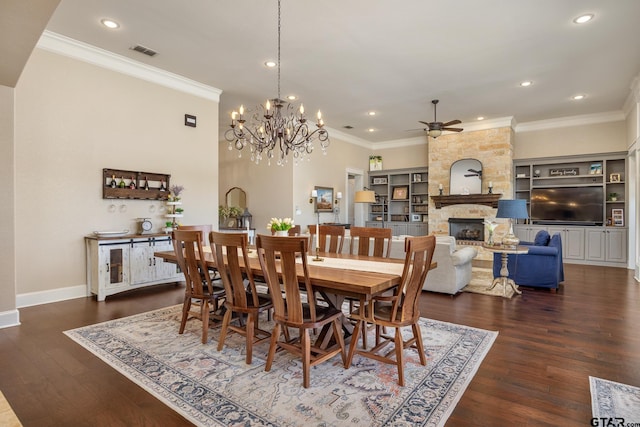 dining room featuring crown molding, visible vents, a fireplace, and wood finished floors