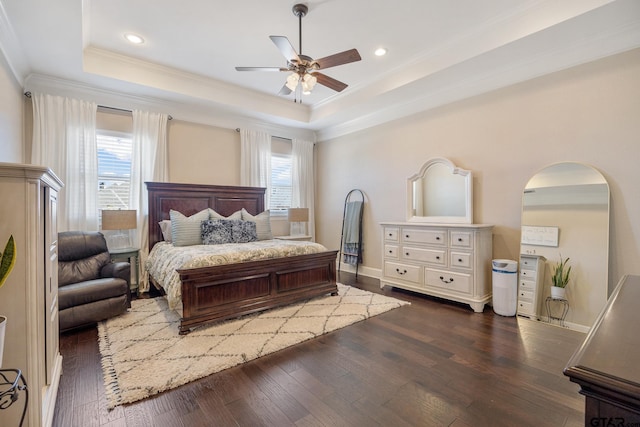 bedroom featuring a tray ceiling, arched walkways, dark wood finished floors, ornamental molding, and baseboards