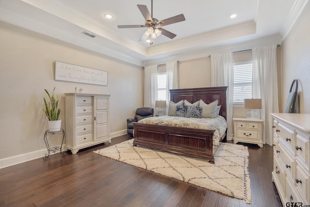 bedroom featuring dark wood-type flooring, a raised ceiling, visible vents, and crown molding