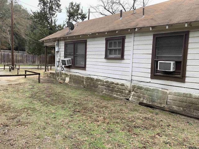 view of home's exterior with cooling unit and a lawn