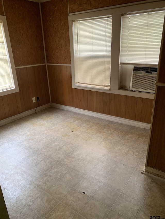 empty room featuring cooling unit and wooden walls