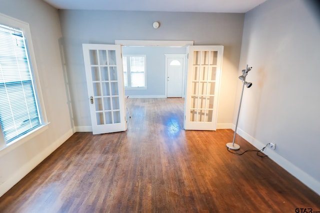 unfurnished room with dark wood-type flooring, a wealth of natural light, and french doors