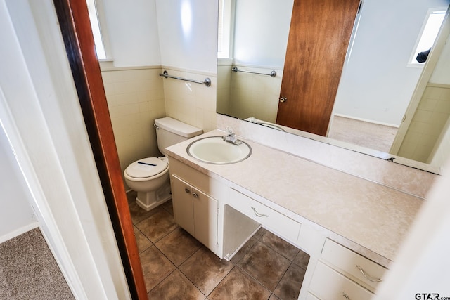 bathroom featuring vanity, tile walls, tile patterned floors, and toilet