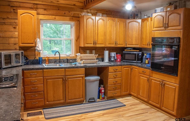 21544 Birch Pl, Tyler, TX 75705 - kitchen featuring oven, stainless steel microwave, a sink, light wood-style flooring, and brown cabinetry