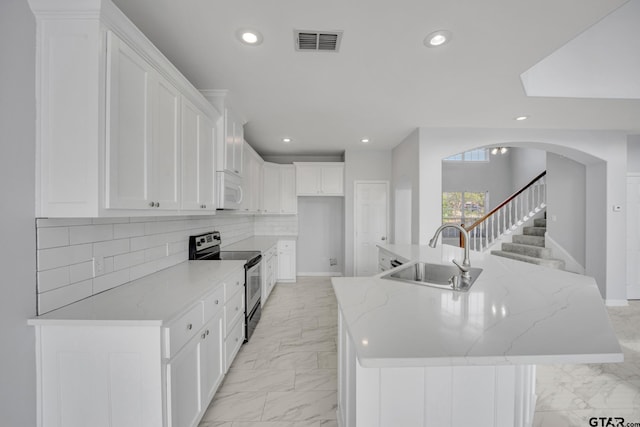 kitchen with white cabinetry, a center island with sink, stainless steel range with electric cooktop, and sink