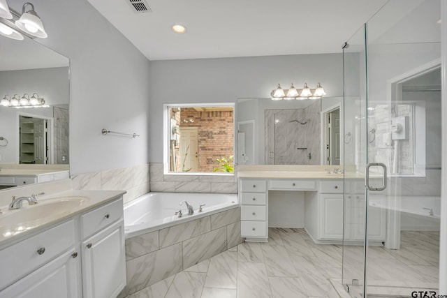 bathroom with vanity and shower with separate bathtub