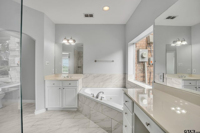 bathroom featuring vanity and tiled tub